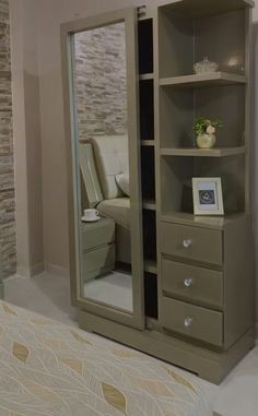 a bedroom with a bed and a large mirror on the wall next to a closet