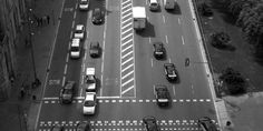 black and white photograph of an overhead view of cars on a city street with traffic lights