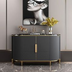 a black and gold cabinet with a painting on the wall next to it in a room