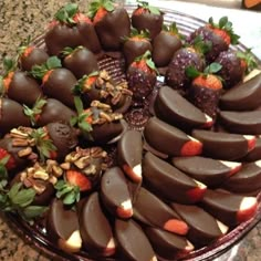 chocolate covered strawberries and almonds are arranged on a platter with other fruit