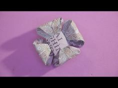 an origami piece on a purple background with the word love written in it