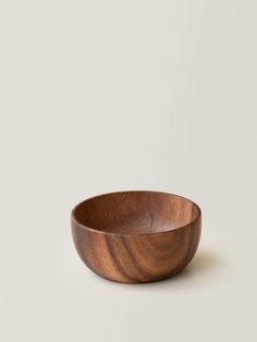 a wooden bowl sitting on top of a white table