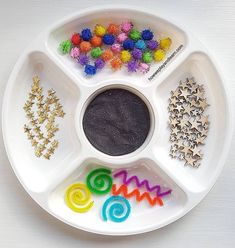 a white plate topped with lots of different types of beads and decorations on top of it