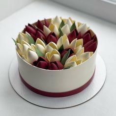 a white cake with red and yellow flowers in it