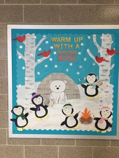 a bulletin board with penguins and polar bears in front of a brick wall that says warm up with a book