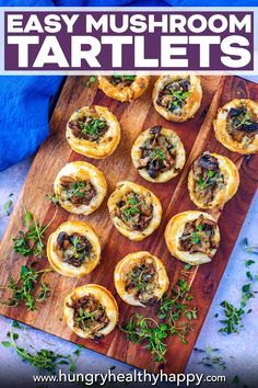 small appetizers on a wooden cutting board with blue napkins and green sprigs