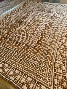 a large brown and white rug on top of a bed