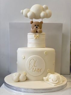 a baby shower cake with a teddy bear on top