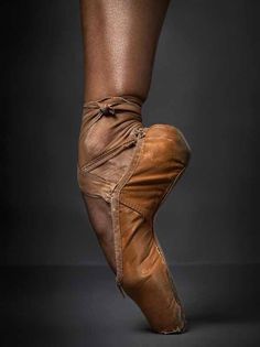 a ballerina's feet in brown ballet shoes