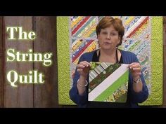 a woman holding up a piece of art with the words the string quilt on it