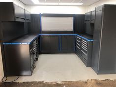 an empty garage with lots of cabinets and drawers