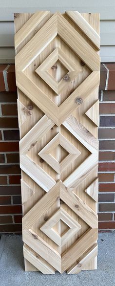 a wooden sculpture sitting next to a brick wall