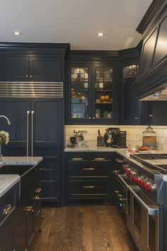 a kitchen with dark blue cabinets and wood flooring is seen in this image from the front view