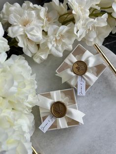 two white flowers and some gold pins