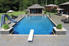 a backyard with a pool and slide in the middle