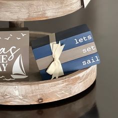 there is a gift set on top of a wooden stand that says let's set sail