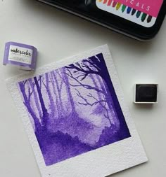 an ink pad and stamp sitting on top of a white table next to a painting