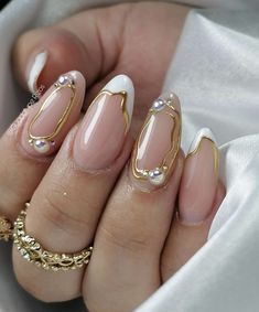 a woman's hand with french manies and gold accents