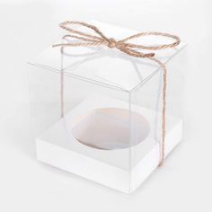 a clear box with a brown string tied around the top and bottom, on a white background