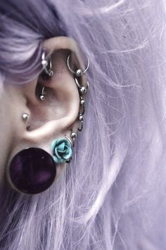 a close up of a person with piercings on their ears and behind the ear