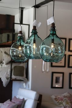 three green glass hanging lights in a living room