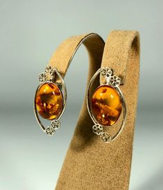 Elevate your style with our Handmade Earrings featuring spectacular orange amber set in textured 925 sterling silver. These exquisite earrings are designed for women who appreciate unique and original jewelry. The vibrant orange amber stones are beautifully complemented by the textured silver, creating a stunning and eye-catching piece that adds a touch of elegance and sophistication to any outfit. Product Details: Material: 925 Sterling Silver Stone: Orange Design: Textured Silver with Unique S Orange Design, Amber Earrings, Amber Stone, Wedding Jewelry Earrings, Original Jewelry, Amber Jewelry, Vibrant Orange, Elegant Gift, Wedding Earrings