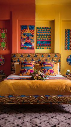 a bedroom with bright colored walls and artwork on the wall