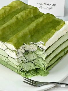 there is a green cake with white frosting on it