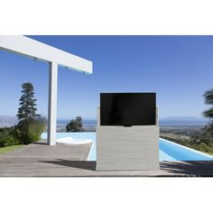 a flat screen tv sitting on top of a cement block next to a swimming pool