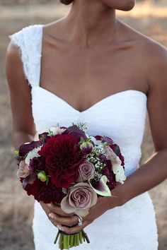 a woman holding a bouquet of flowers in her hands