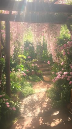 the sun shines brightly on a garden with pink flowers and greenery, as well as steps leading up to it