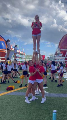 two cheerleaders are standing on top of each other