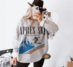 Après Ski Sweatshirt" is the perfect cozy addition for those post-slope gatherings or winter festivities. Whether you're at a ski resort, a mountain getaway, or a bachelorette party in Aspen, this sweatshirt brings style and warmth. Ideal for ski-themed parties, camp bachelorette weekends, or simply lounging by the fireplace after a day in the snow, it's a must-have for any winter adventure. Embrace the fun of the season with this stylish après-ski sweater that captures the spirit of snowy mount Long Sleeve Ski Tops For Ski Season, Long Sleeve Skiing Tops For Ski Season, Long Sleeve Tops For Ski Season And Winter Sports, Long Sleeve Tops For Ski Season, Ski Bachelorette, Mountain Bachelorette, Apres Ski Sweater, Ski Sweatshirt, Ski Wedding