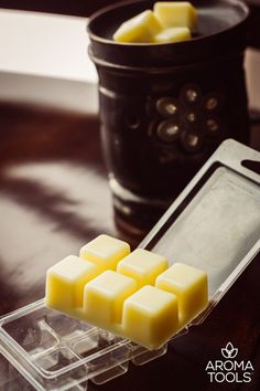 several cubes of wax sitting on top of a table next to a glass container