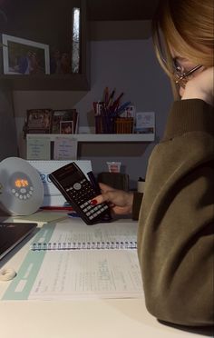 a woman sitting at a desk with a calculator