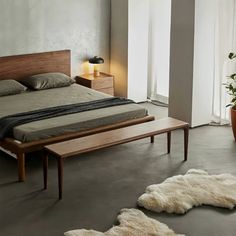 a bedroom with a bed, nightstands and two planters on either side of the bed