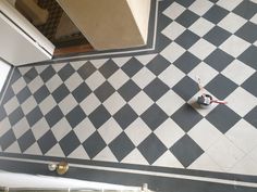 a black and white checkered tile floor in a room with an open door to another room