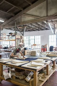 a man is working on some wood in a workshop with lots of workbench