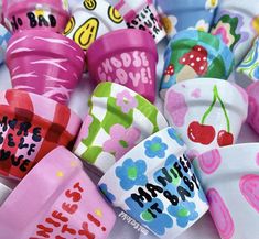 many different colored plastic cups with designs on them and the words hello kitty written in large letters