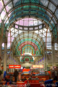 the inside of a building with lots of glass and metalwork on it's ceiling