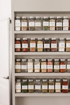 an organized spice rack in a kitchen with lots of spices and herbs on the shelves