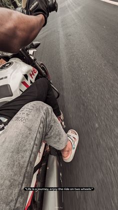 a man riding on the back of a motorcycle down a street