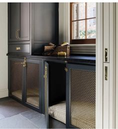 a kitchen with black cabinetry and gold handles on the doors, along with a dog bed