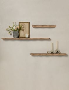 two wooden shelves with flowers and candles on them