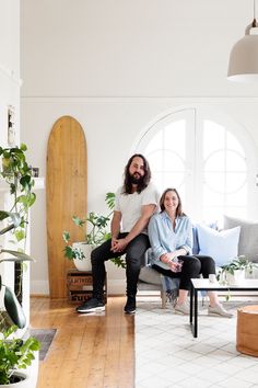 a man and woman sitting on a couch in a living room next to each other