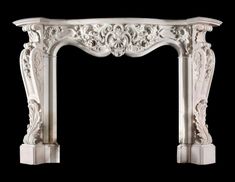 an ornate white marble fireplace mantel with carvings on the top and sides, against a black background