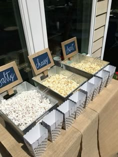 two trays filled with popcorn sitting on top of a table next to each other