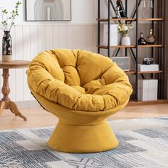 a yellow chair sitting on top of a rug in a living room