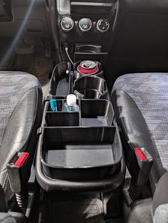 the interior of a vehicle with several items in its trays on the back seat