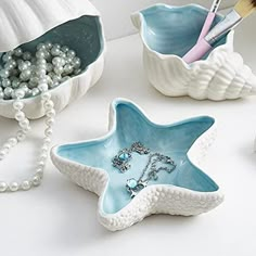 three starfish shaped dishes with pearls and beads in the bowl next to one another